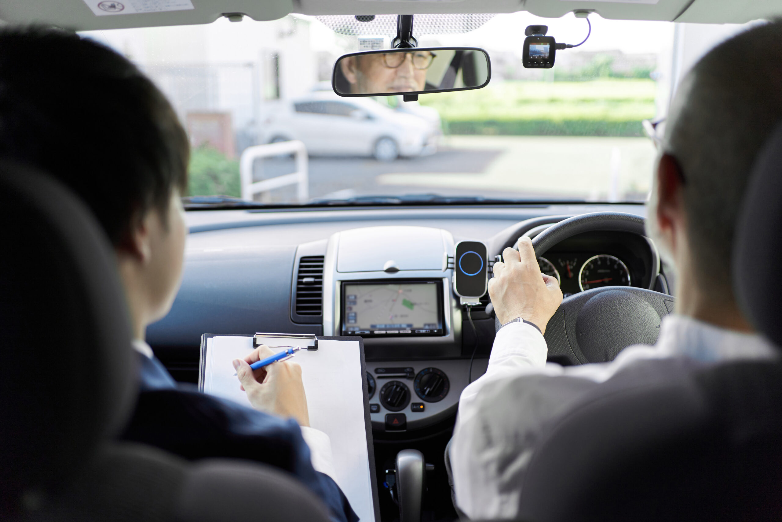 Elderly people taking training in driving a car