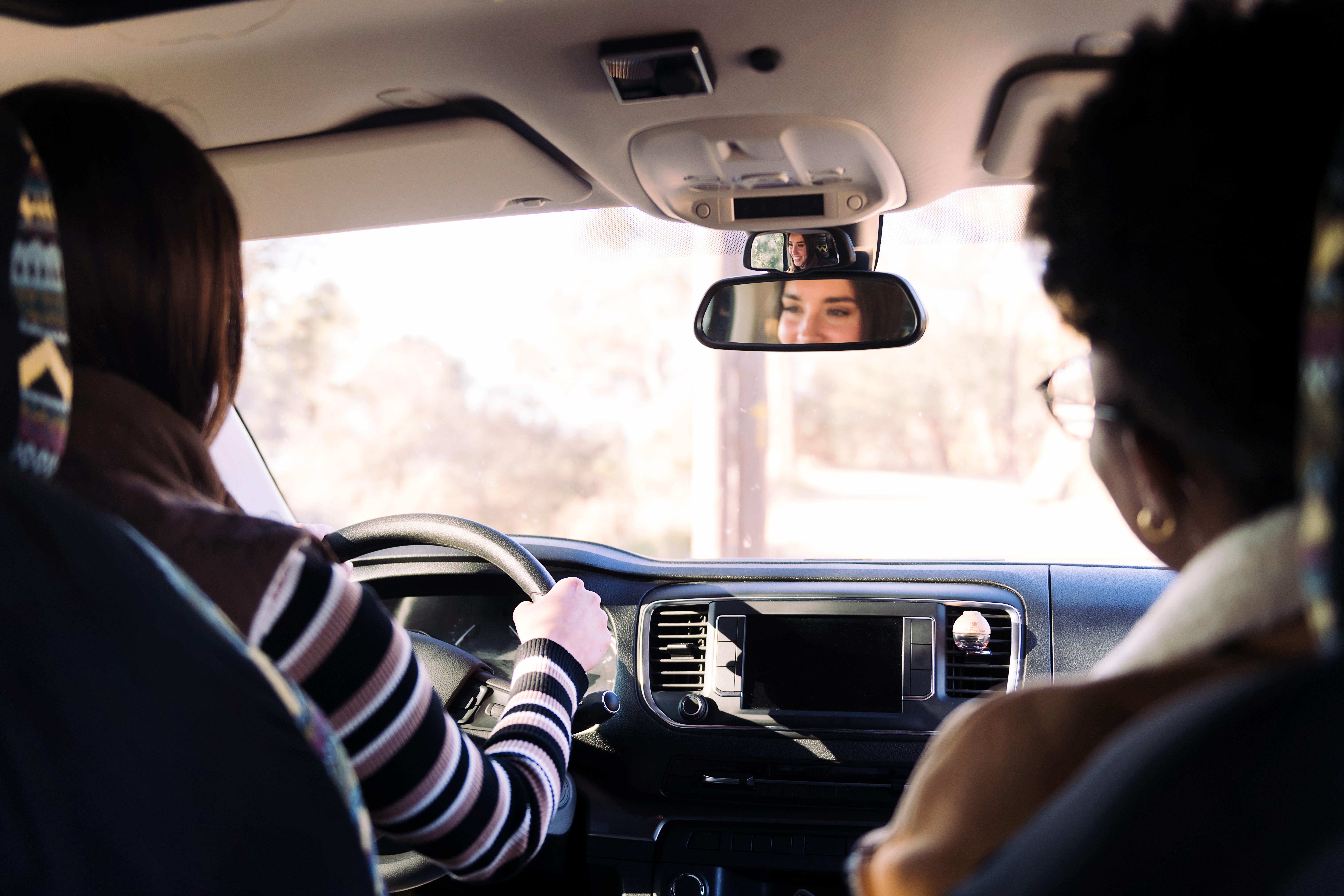 rear view of two best friends traveling in a camper van on a road trip, concept of adventure and female friendship